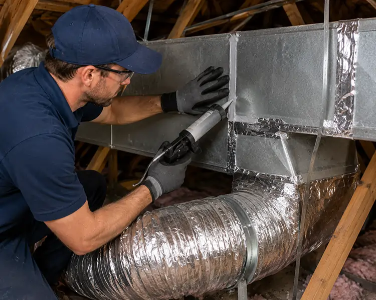 HVAC technician sealing metal air ducts with professional duct mastic to eliminate air leaks